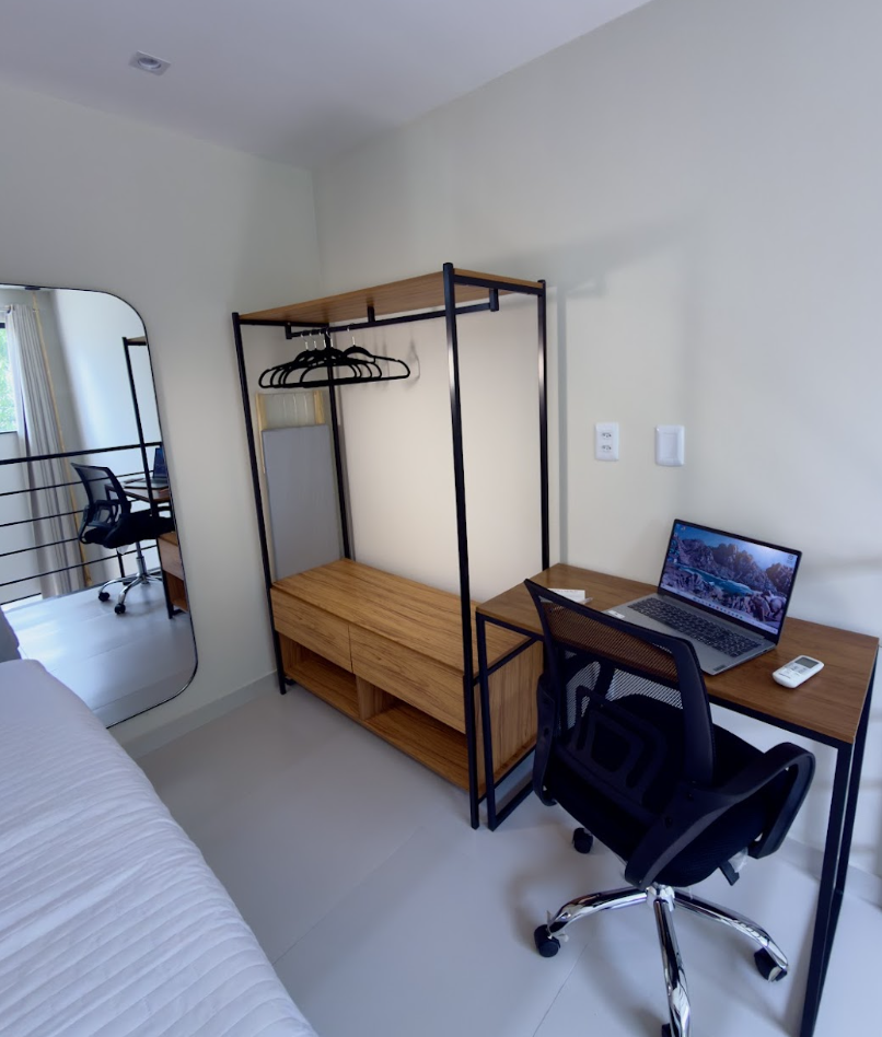 Mezanino com guarda-roupa rack de ferro e madeira e mesa de trabalho com notebook aberto